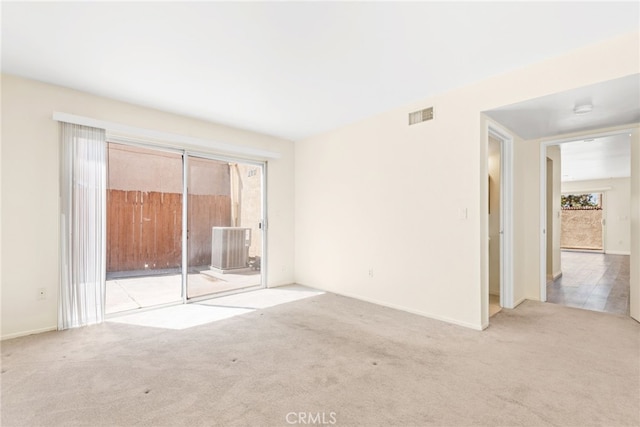 unfurnished bedroom with carpet flooring, multiple windows, access to exterior, and visible vents