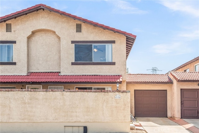 view of front facade featuring driveway, stucco siding, and a garage