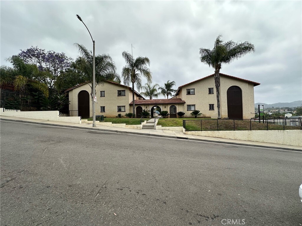 view of front of home featuring stucco siding and fence