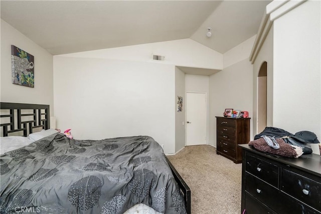 bedroom featuring light carpet, visible vents, arched walkways, and lofted ceiling