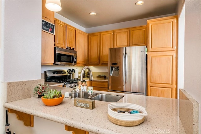 kitchen featuring a sink, recessed lighting, light stone countertops, and appliances with stainless steel finishes