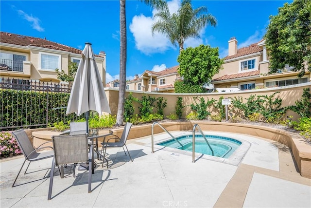 view of swimming pool featuring outdoor dining area, fence private yard, a hot tub, and a patio area