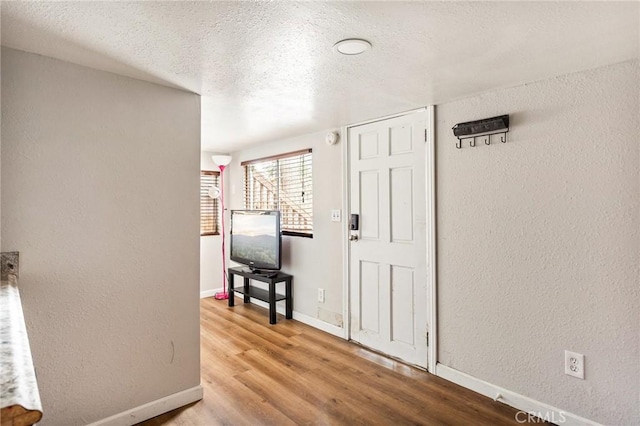 31662 Panorama Dr, Running Springs, CA 92382 - foyer featuring wood finished floors, a textured wall, a textured ceiling, and baseboards