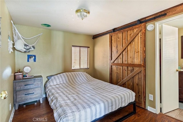 31662 Panorama Dr, Running Springs, CA 92382 - bedroom featuring a barn door, wood finished floors, and baseboards