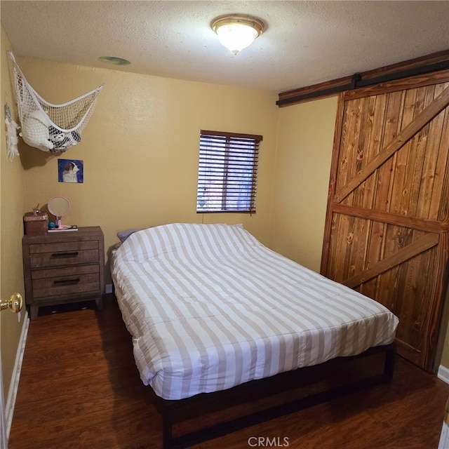 31662 Panorama Dr, Running Springs, CA 92382 - bedroom with wood finished floors, a textured ceiling, baseboards, and a barn door