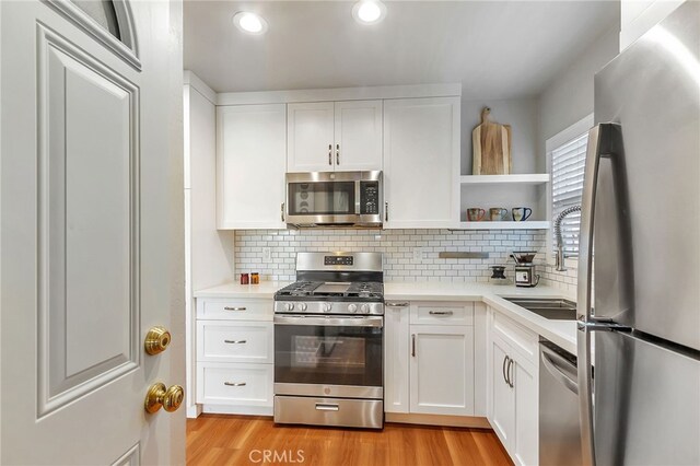 1012 S 11th St, San Jose, CA 95112 - kitchen with appliances with stainless steel finishes, open shelves, light countertops, light wood-style flooring, and recessed lighting