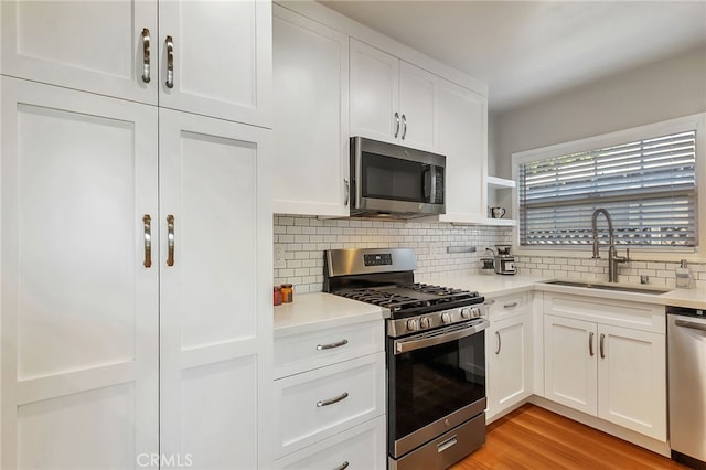 1012 S 11th St, San Jose, CA 95112 - kitchen with appliances with stainless steel finishes, a sink, decorative backsplash, and white cabinetry