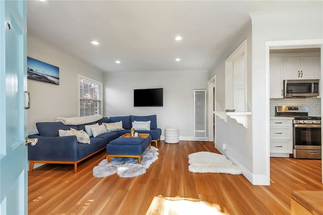 1012 S 11th St, San Jose, CA 95112 - living area with a heating unit, light wood finished floors, recessed lighting, and baseboards