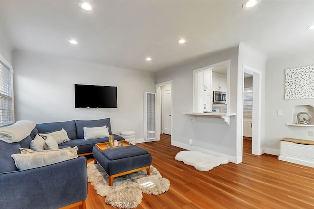 1012 S 11th St, San Jose, CA 95112 - living area with a heating unit, wood finished floors, baseboards, and recessed lighting