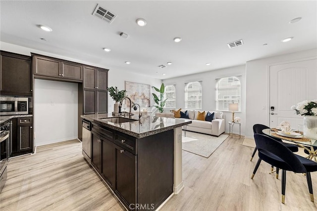16022 Voyager Ave, Chino, CA 91708 - kitchen with a sink, appliances with stainless steel finishes, dark stone countertops, light wood-style flooring, and dark brown cabinetry