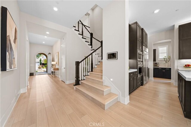 107 Balance, Irvine, CA 92618 - foyer featuring arched walkways, stairway, light wood-style flooring, and recessed lighting