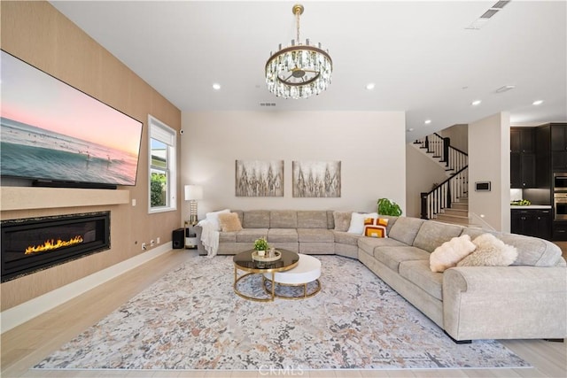 107 Balance, Irvine, CA 92618 - living room featuring wood finished floors, stairs, recessed lighting, a glass covered fireplace, and a chandelier