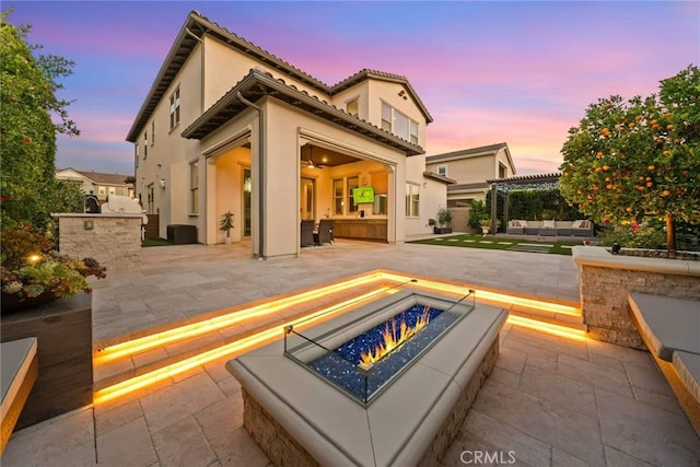 107 Balance, Irvine, CA 92618 - rear view of house with a patio area, an outdoor kitchen, stucco siding, and an outdoor living space with a fire pit