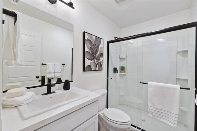 bathroom with visible vents, toilet, a stall shower, and vanity