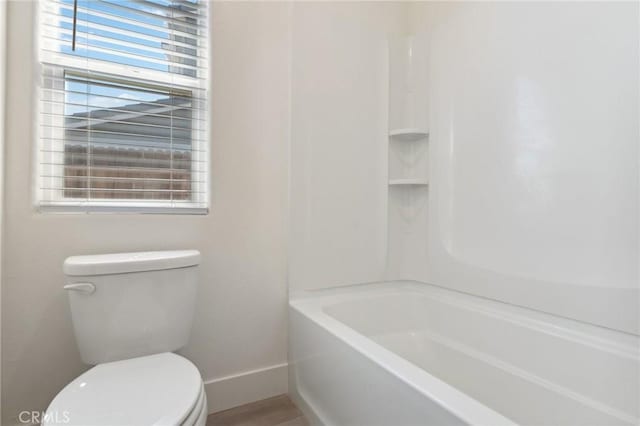 bathroom with baseboards and toilet