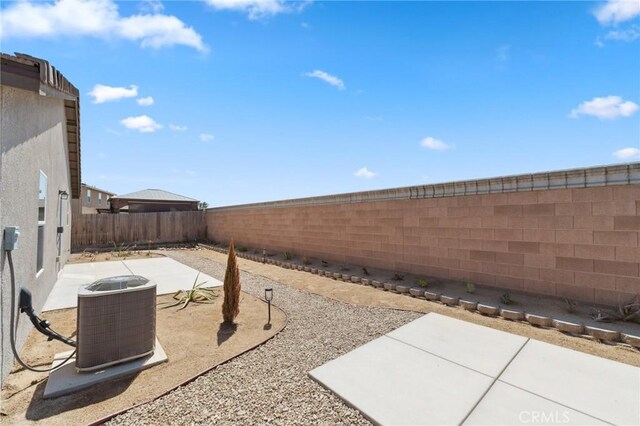view of yard featuring a fenced backyard, central air condition unit, and a patio