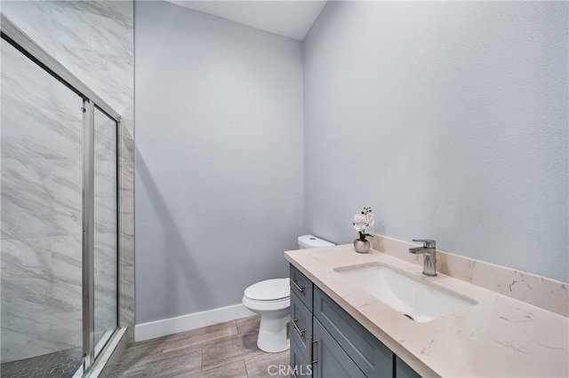 full bath with toilet, a marble finish shower, vanity, and baseboards
