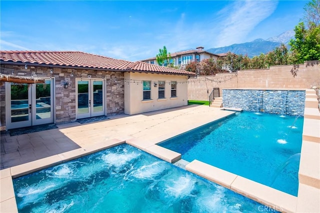 view of pool with a mountain view, a fenced backyard, french doors, and a patio area