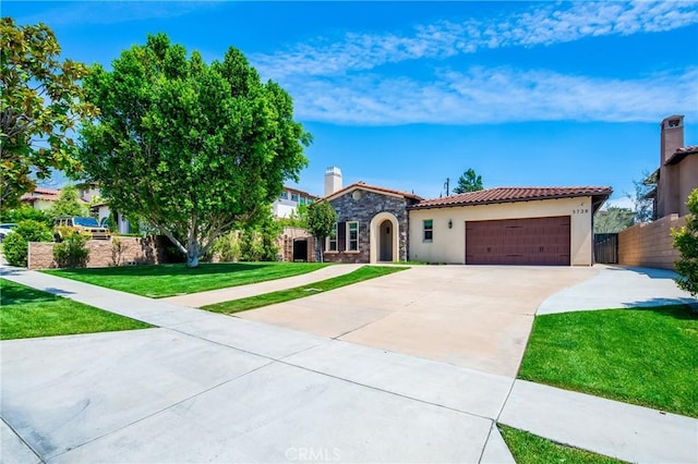 mediterranean / spanish-style house featuring stucco siding, a garage, a tile roof, stone siding, and concrete driveway