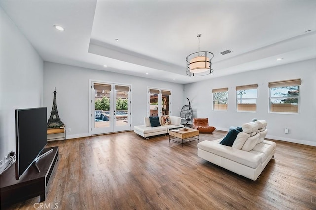 living room featuring recessed lighting, visible vents, a healthy amount of sunlight, and a tray ceiling