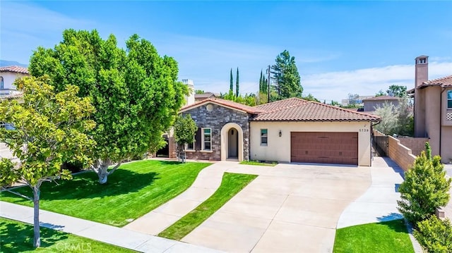 mediterranean / spanish-style house featuring a front lawn, a garage, a tiled roof, concrete driveway, and stucco siding