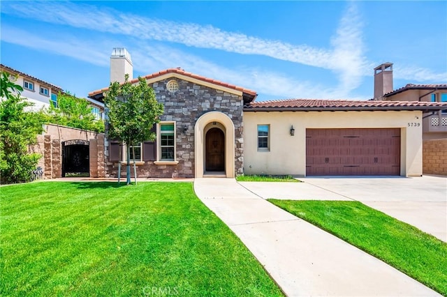 mediterranean / spanish home featuring a front yard, a tiled roof, a chimney, concrete driveway, and stucco siding