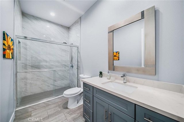 full bath with a marble finish shower, toilet, and vanity