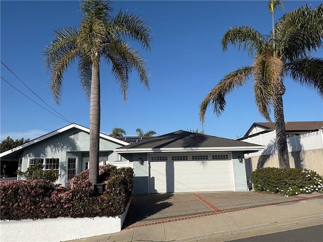 ranch-style house featuring stucco siding, fence, concrete driveway, and a garage