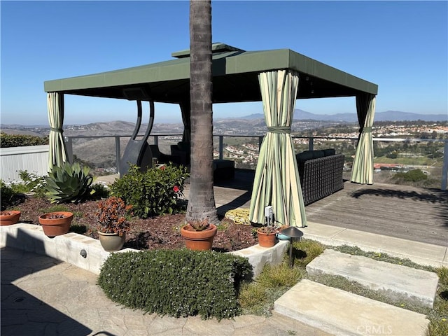 exterior space with a gazebo, a deck with mountain view, and fence