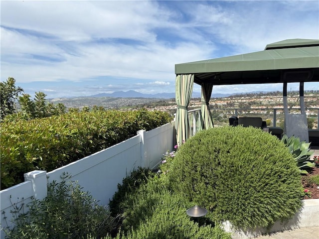 view of yard featuring a gazebo, fence, and a mountain view