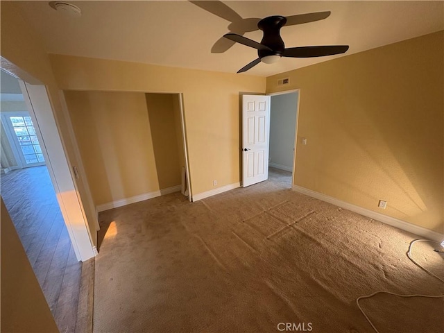 interior space featuring ceiling fan, baseboards, carpet floors, and visible vents
