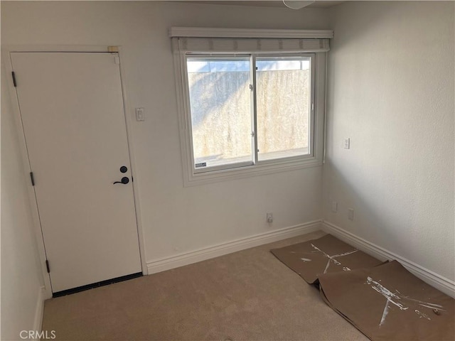 carpeted entrance foyer featuring a wealth of natural light and baseboards