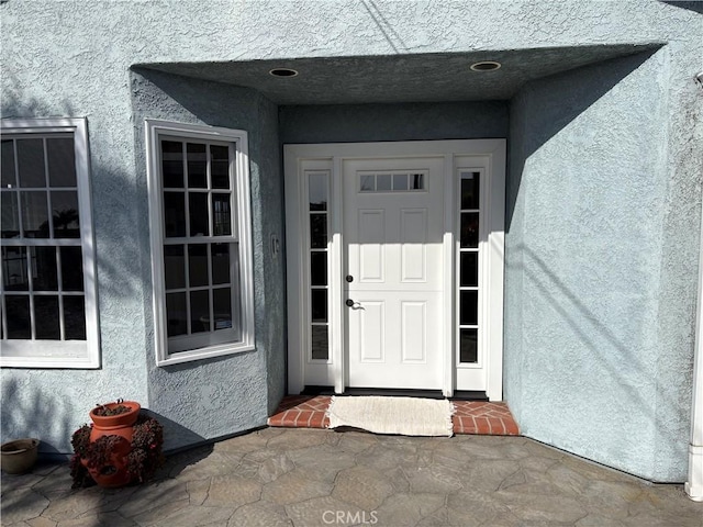 property entrance with stucco siding