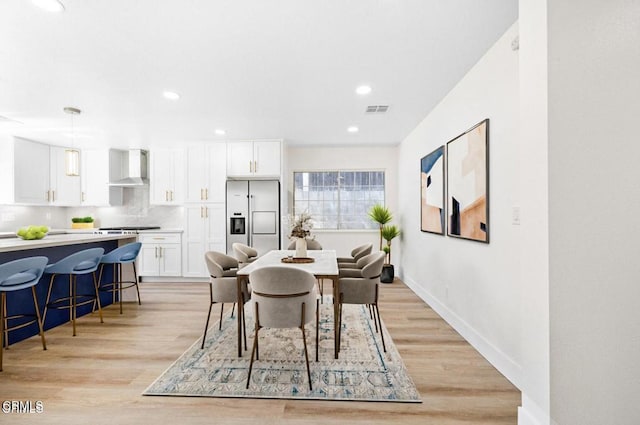 dining area with baseboards, light wood finished floors, visible vents, and recessed lighting