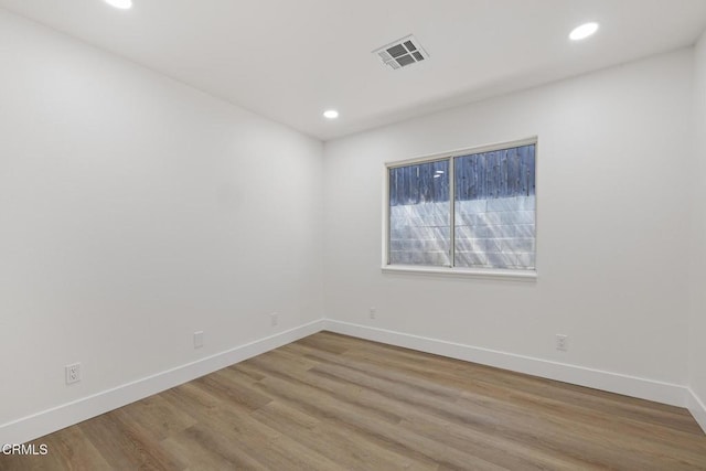 unfurnished room featuring baseboards, visible vents, and recessed lighting