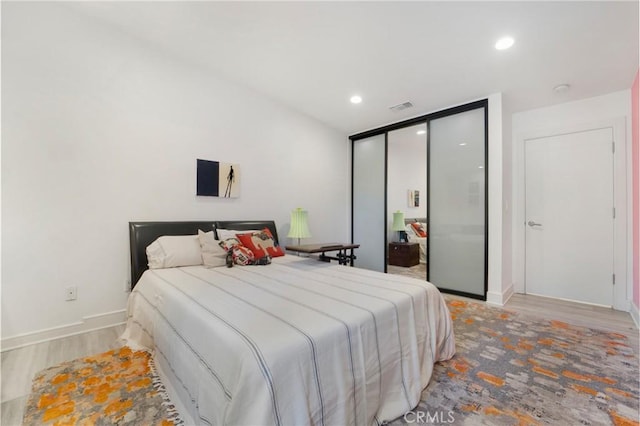 bedroom with recessed lighting, visible vents, baseboards, and wood finished floors