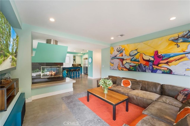 living room featuring recessed lighting, visible vents, baseboards, and a multi sided fireplace