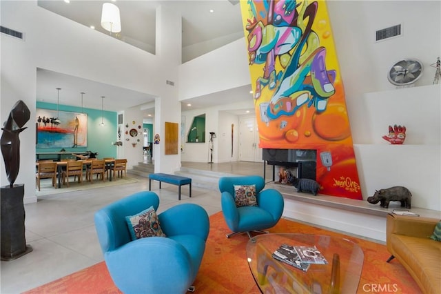 living room featuring a towering ceiling and visible vents