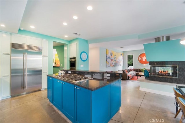 kitchen with finished concrete floors, visible vents, blue cabinetry, and appliances with stainless steel finishes