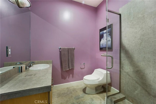 bathroom with a shower stall, vanity, tile patterned flooring, toilet, and baseboards