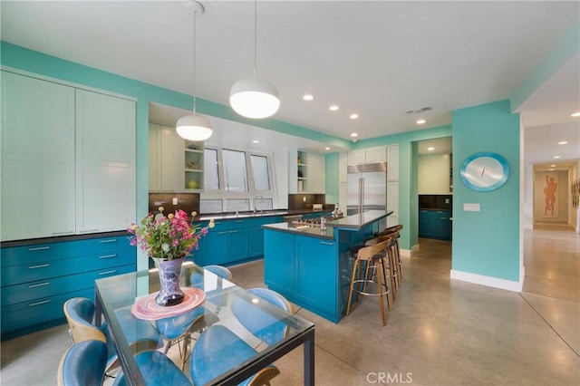 kitchen with built in refrigerator, open shelves, dark countertops, visible vents, and concrete flooring