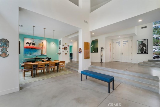 interior space featuring a high ceiling, concrete flooring, visible vents, and recessed lighting