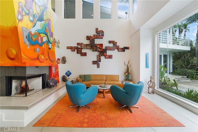living area featuring a fireplace, a high ceiling, and tile patterned flooring