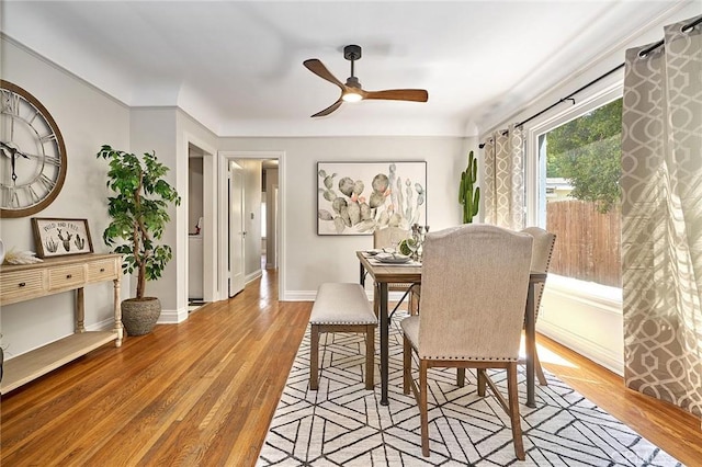 dining room with wood finished floors, baseboards, and a ceiling fan