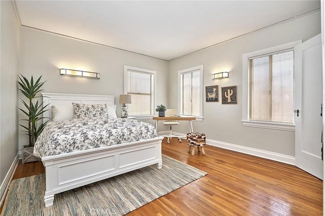 bedroom featuring wood finished floors and baseboards