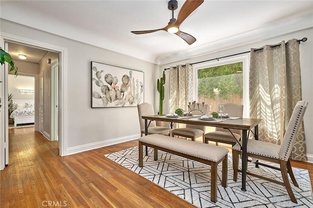 dining room with light wood-type flooring, baseboards, and a ceiling fan