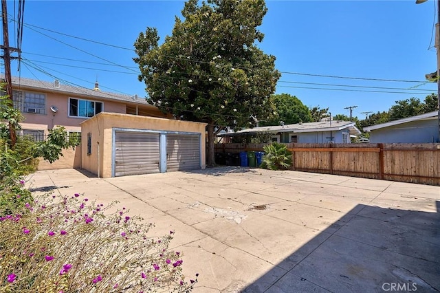 exterior space featuring an outbuilding, a detached garage, and fence