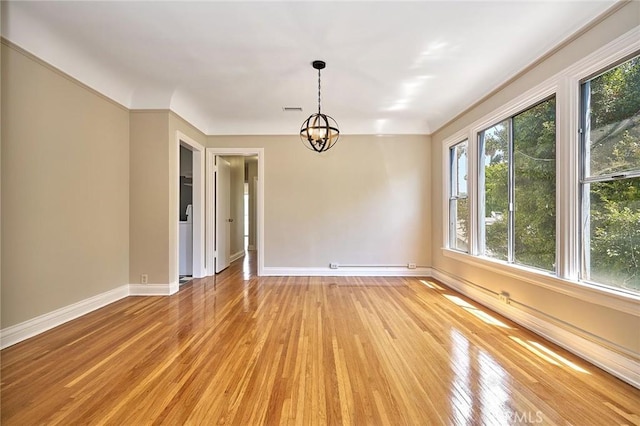 spare room with a chandelier, visible vents, light wood-type flooring, and baseboards