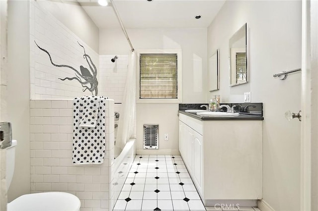 bathroom with shower / bath combination with curtain, vanity, visible vents, toilet, and baseboards