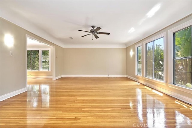 unfurnished room with light wood-style floors, baseboards, and ceiling fan